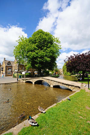 Stone footbridge across the River Windrush with tea-rooms to the rear, Bourton on the Water, Gloucestershire, England, UK, Western Europe.のeditorial素材