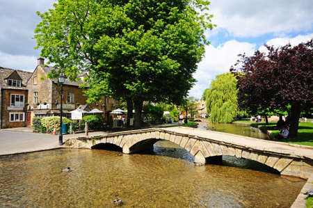 Stone footbridge across the River Windrush with tea-rooms to the rear, Bourton on the Water, Gloucestershire, England, UK, Western Europe.のeditorial素材