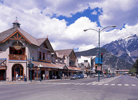 View of the shops along the main street through Banff town with snow capped mountains to the rear Banff Banff National Park Alberta Canada.のeditorial素材