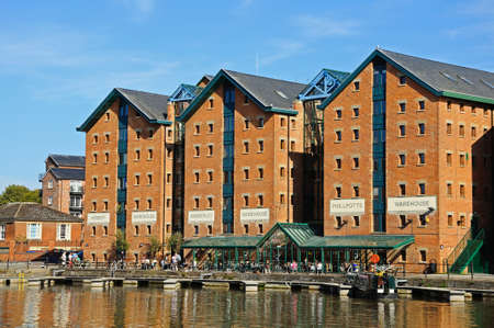 Pleasure boats moored in Gloucester Docks with warehouses and a pavement cafe to the rear Gloucester Gloucestershire England UK Western Europe.のeditorial素材