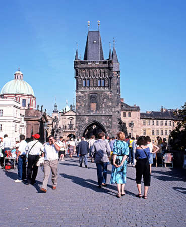 Tourists walking across Charles Bridge towards the Old Town Bridge Tower, Prague, Czech Republic, Central Europe.のeditorial素材