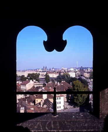 City rooftops seen through a shaped stone window, Prague, Czech Republic, Central Europe.