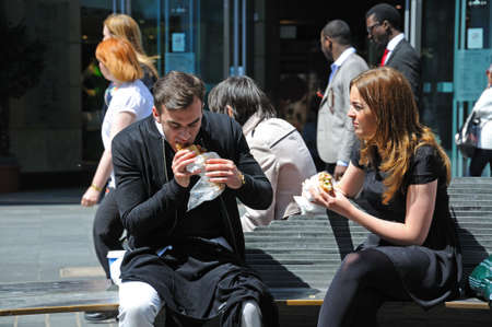 Couple sitting on a bench having a takeaway lunch along Whitechapel shoping street in the city centre, Liverpool, Merseyside, England, UK, Western Europe.のeditorial素材