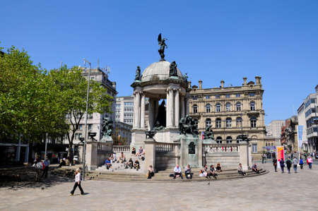 The Queen Victoria monument in Derby Square with tourists sitting on the steps enjoying the Summer sunshine, Liverpool, Merseyside, England, UK, Western Europe.のeditorial素材