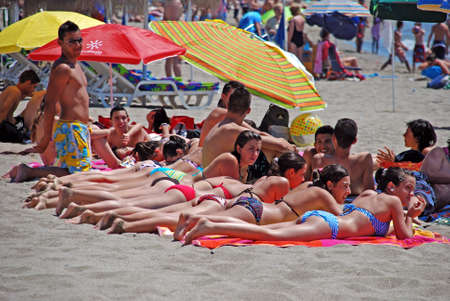 Row of young women sunbathing on beach, Fuengirola, Costa del Sol, Malaga Province, Andalucia, Spain, Western Europe.のeditorial素材