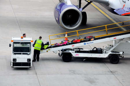 Bags being loaded onto aircraft on a conveyer belt at Birmingham airport, Birmingham, West Midlands,...