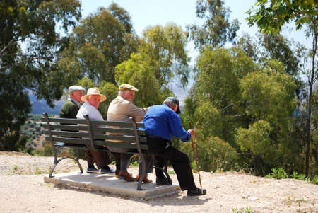Four elderly Spanish men sitting on bench, Periana, Costa del Sol, Malaga Province, Andalusia, Spain, Western Europe.のeditorial素材