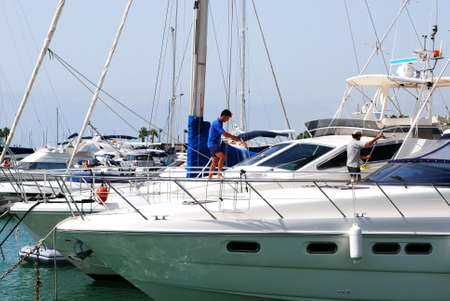 Men cleaning a yacht in the marina, Puerto Sotogrande, Cadiz Province, Andalucia, Spain, Western Europe.のeditorial素材