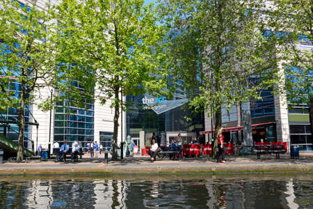 View towards the rear of the ICC with people relaxing in the foreground at Brindleyplace, Birmingham, England, UK, Western Europe.のeditorial素材