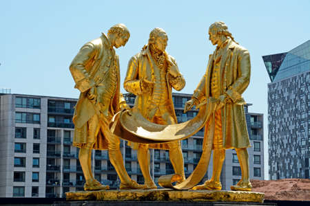 View of the golden Boulton, Watt and Murdoch statue in Centenary Square, Birmingham, England, UK, Western Europe.のeditorial素材