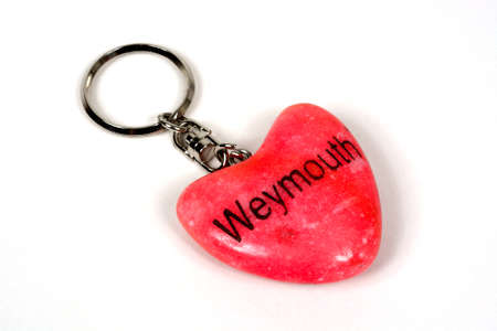 Pink stone heart key ring from Weymouth against a white background, Weymouth, Dorset, England, UK,...