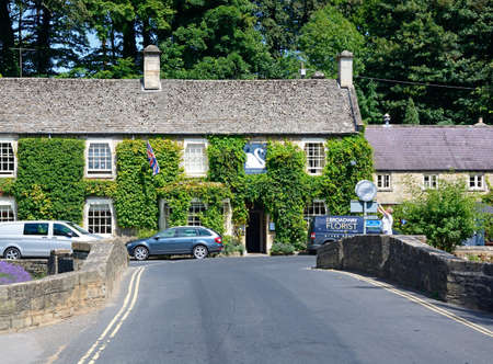 View across the road bridge towards The Swan Hotel, Bibury, Cotswolds, Gloucestershire, England, UK,...
