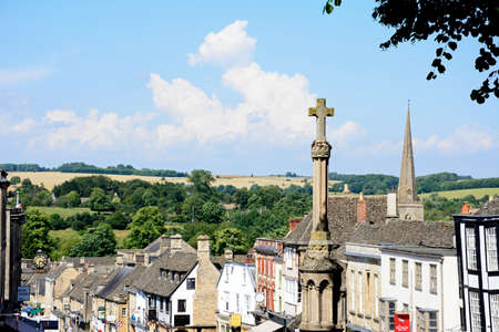 View of shops and businesses along The Hill shopping street with the war memorial in the foreground, Burford, Oxfordshire, England, UK, Western Europe.のeditorial素材