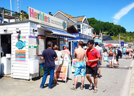 Tourists queuing to buy fish and chips from a beachfront chip shop, Lyme Regis, Dorset, England, UK, Western Europe.のeditorial素材