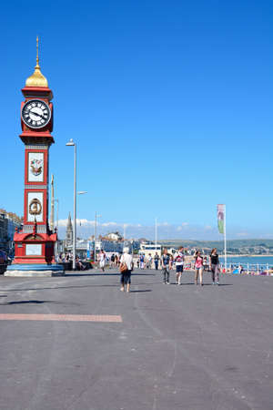 View along the Esplanade promenade and coastline with Queen Victorias Jubilee clock tower in the foreground, Weymouth, Dorset, England, UK, Western Europe.のeditorial素材