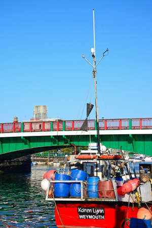 View of the twin leaf bascule bridge and with a fishing boat in the foreground, Weymouth, Dorset, England, UK, Western Europe.のeditorial素材