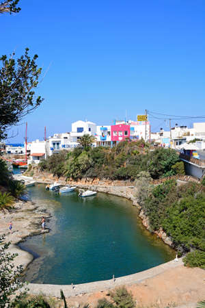 Elevated view of boats moored in the harbour with waterfront restaurants to the rear and tourists enjoying the setting, Sissi, Crete, Greece, Europe.のeditorial素材