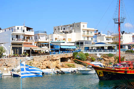Black Rose Pirate ship moored in the harbour with waterfront restaurants to the rear, Sissi, Crete, Europe.のeditorial素材