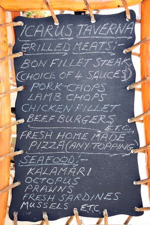 Greek Taverna menu chalkboard showing traditional and international dishes, Kalyves, Crete, Greece, Europe.のeditorial素材