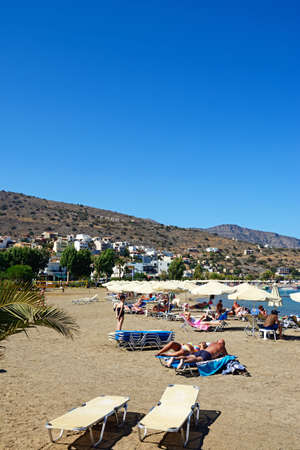 Tourists relaxing on the beach, Elounda, Crete, Greece, Europe.のeditorial素材