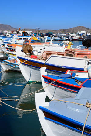 Traditional Greek fishing boats moored in the harbour, Elounda, Crete, Greece, Europe.のeditorial素材