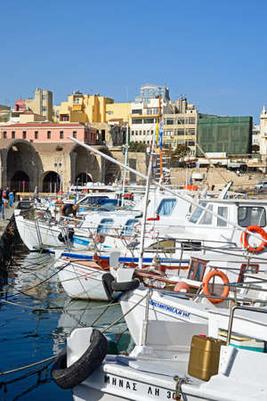 Fishing boats and yachts moored in the harbour with waterfront buildings to the rear, Heraklion, Crete, Greece, Europe.のeditorial素材