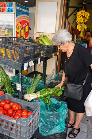 Customer choosing fruit and vegetables at a city centre shop along Odos 1821, Heraklion, Crete, Greece, Europe.のeditorial素材