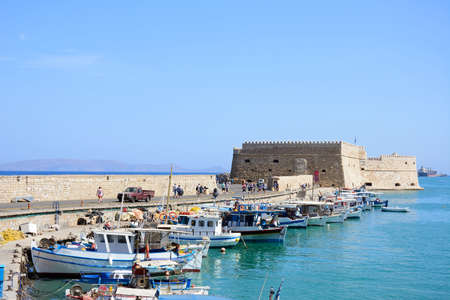 Traditional fishing boats moored in the harbour with Koules castle to the rear, Heraklion, Crete, Greece, Europe.のeditorial素材