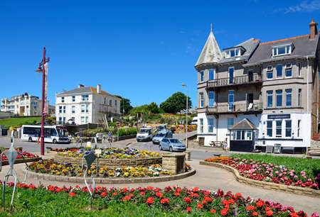 Pretty flowerbeds on a traffic island with town buildings to the rear, Seaton, Devon, England, UK, Western Europe.のeditorial素材