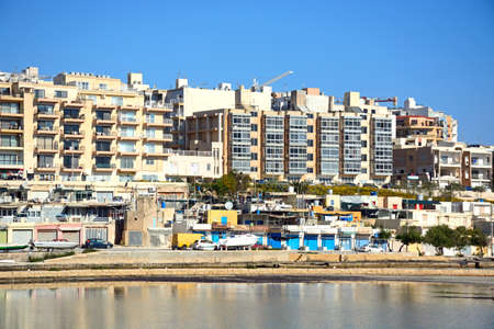 View of salt pans with buildings to the rear in Salina Bay, Bugibba, Malta, Europe.のeditorial素材
