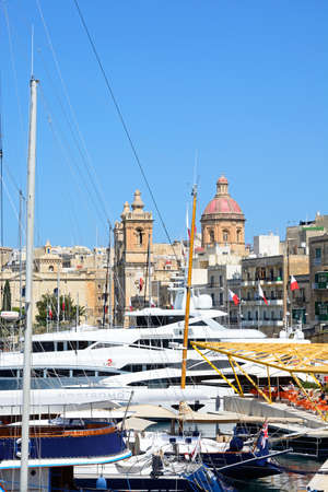 Yachts moored in the marina with views towards St Lawrence church and waterfront buildings, Vittoriosa, Malta, Europe.のeditorial素材