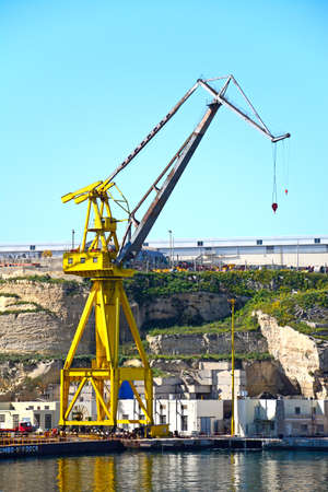 Industrial cranes in the docks with buildings to the rear, Paola, Malta, Europe.のeditorial素材