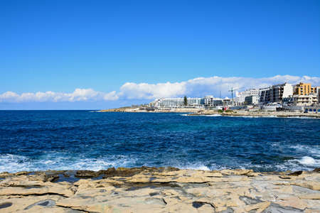 View of the rocky coastline with hotels and apartments to the rear, Bugibba, Malta, Europe.のeditorial素材