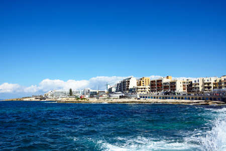 View of the rocky coastline with hotels and apartments to the rear, Bugibba, Malta, Europe.のeditorial素材