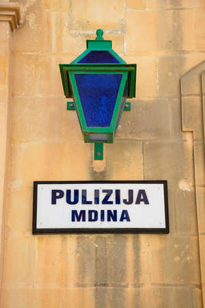 Wall lantern above a police station sign, Mdina, Malta, Europe.の写真素材
