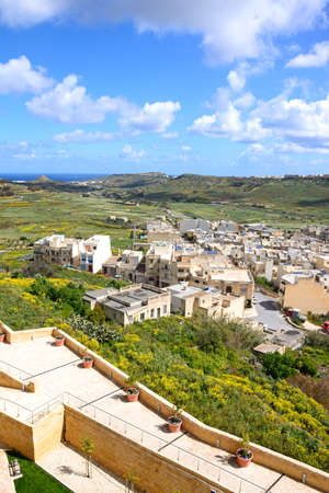 Elevated view of fortified buildings and the landscaped old moat within the citadel with views over the town rooftops towards the countryside and sea, Victoria (Rabat), Gozo, Malta, Europe.の写真素材