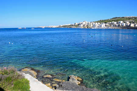 Shoreline with views across the bay towards St Pauls Bay, San Pawl, Malta, Europe.の写真素材