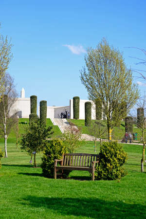 Front view of the Armed Forces Memorial with landscaped gardens and a wooden bench in the foreground, National Memorial Arboretum, Alrewas, Staffordshire, England, UK, Western Europe.のeditorial素材