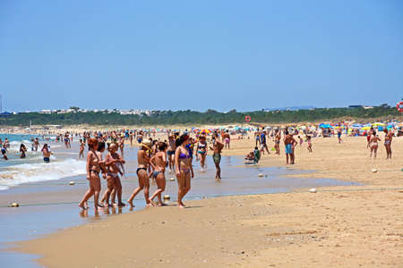 Tourists relaxing on the beach during the Summertime with views along the coastline, Praia da Monte Gordo, Vila Real de Santo Antonio, Algarve, Portugal, Europe.のeditorial素材