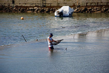 Fisherman wading along the River Gilao, Tavira, Algarve, Portugal, Europe.のeditorial素材