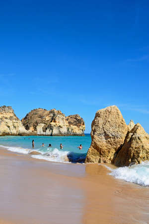 Tourists relaxing on the beach and in the sea, Praia da Rocha, Portimao, Algarve, Portugal, Europe.