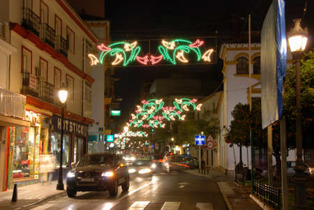 Festive Christmas light decoration suspended across a town centre shopping street at night, Fuengirola, Costa del Sol, Malaga Province, Andalucia, Spain, Europe.のeditorial素材