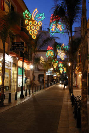 Christmas decorations along a town centre street at dusk, Fuengirola, Costa del Sol, Malaga Province, Andalucia, Spain.のeditorial素材
