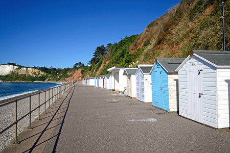 SEATON, UK- AUGUST 30, 2022 - Beach huts alongside the beach with views towards Beer Head, Seaton, Devon, UK, Europe, August 30, 2022.のeditorial素材