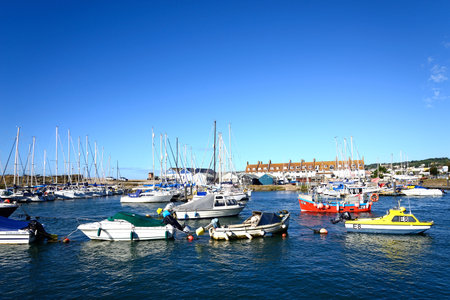 AXMOUTH, UK - AUGUST 30, 2022 - Fishing boats and yachts moored along the River Axe in the harbour with town buildings and Seaton to the rear, Axmouth, Devon, UK, Europe, August 30, 2022.のeditorial素材