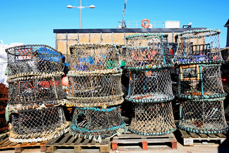 WEST BAY, UK - OCTOBER 10, 2022 - Collection of lobster pots stacked along the harbourside, West Bay, Dorset, UK, Europe, October, 2022.のeditorial素材