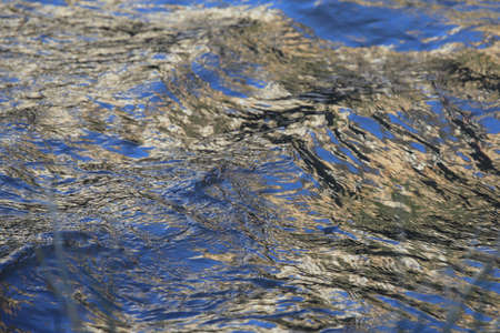 background of colorful and iridescent reflections on the surface of running waterの写真素材