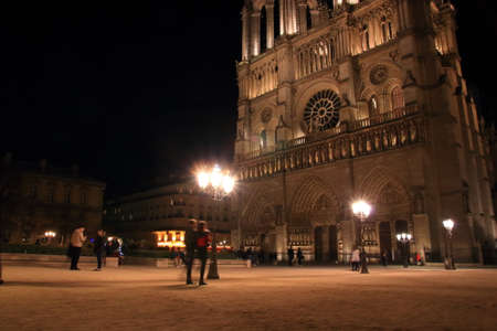 Notre Dame Cathedral in Paris and its lighting with tourists at night, Franceの写真素材