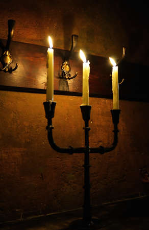 Burning candles with antique metal candlestickの写真素材