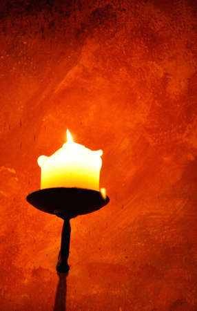 Burning candle in an old candle holderの写真素材